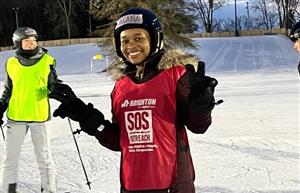 student on skiis giving peace sign 